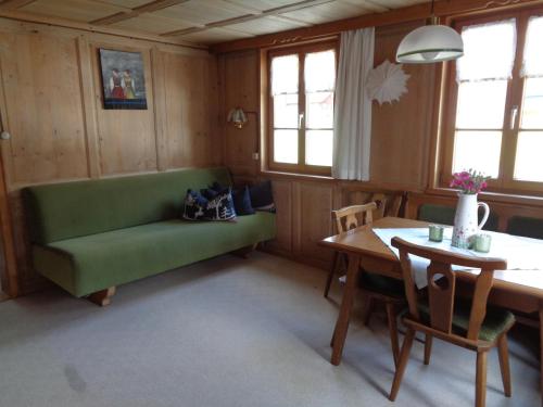 a living room with a green couch and a table at Ferienwohnung Berktold in Bizau