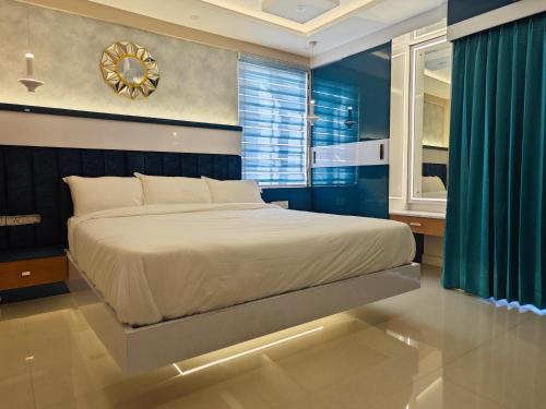 a bedroom with a large bed and a clock on the wall at Evara - Premium Fully AC - 3BHK Luxury Apartment with Style in Trivandrum