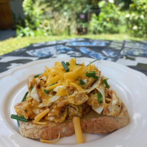 a piece of bread with cheese and vegetables on a plate at Highview Lodge in Gillitts