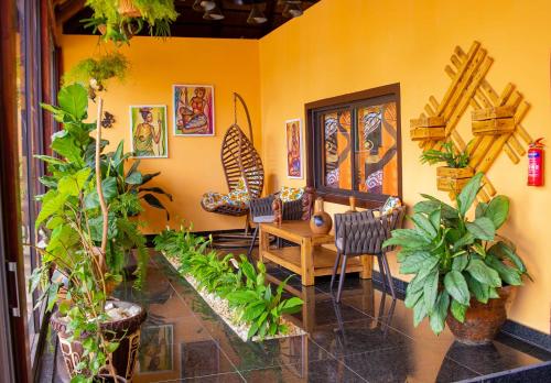 a room with a table and chairs and plants at Kimbo do Soba Resort in Sá da Bandeira
