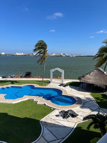 a swimming pool with a view of the water at Penthouse frente a la Laguna in Cancún