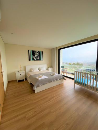 a bedroom with a bed and a large window at Esperança Terrace in Braga