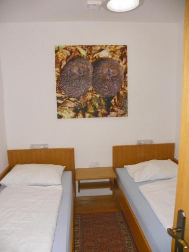 two beds in a room with a painting on the wall at Ferienwohnung Ski-Hans in Planneralm