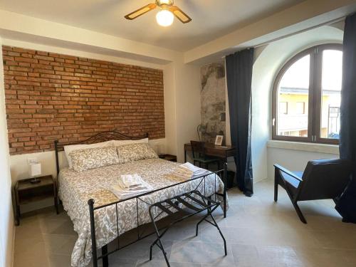 a bedroom with a bed and a brick wall at Castello D'Alcontres Guest House 3 stelle in Nizza di Sicilia