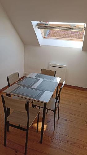 - une table et des chaises dans une chambre dotée d'une lucarne dans l'établissement L'Écrin Boulonnais, à Boulogne-sur-Mer