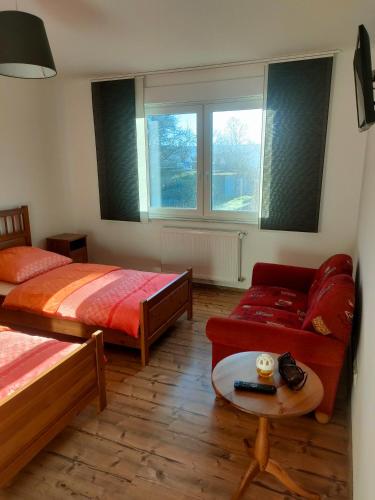 a bedroom with two beds and a couch and a table at Pension Katja in Zweibrücken