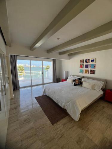 a bedroom with a large bed with a view of the ocean at Penthouse frente a la Laguna in Cancún