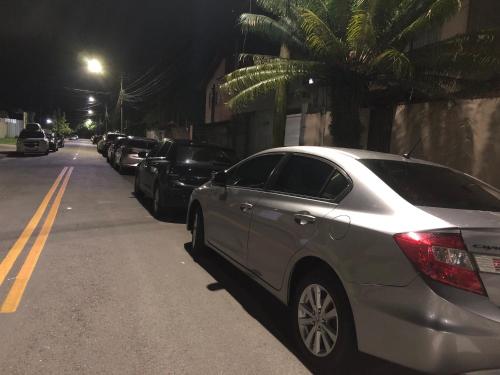 a silver car parked on the side of a street at night at Suíte privativa próxima ao Sesc 3 in Bertioga
