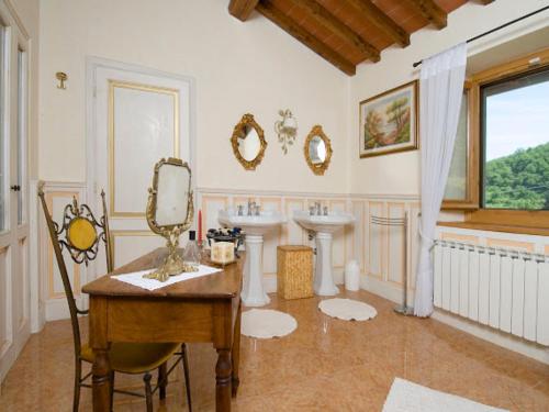 a bathroom with two sinks and a mirror at Villa La Fonte 13 in San Godenzo