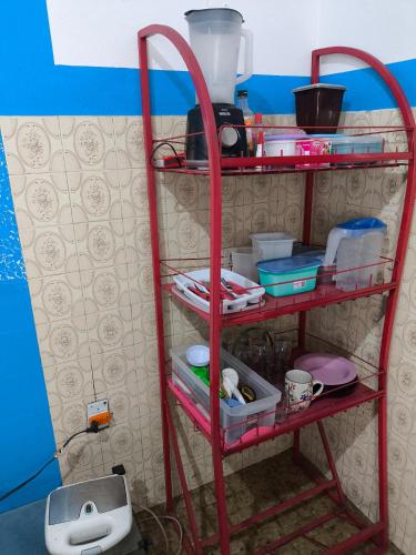 a red shelf with dishes and other items on it at Quartos Econômicos in Manaus
