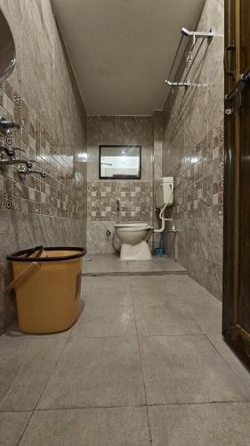 a bathroom with a toilet and a window on the wall at The Kumbh Comfort Homestay in Prayagraj