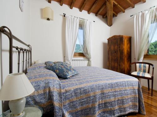 a bedroom with a bed with a blue blanket and a lamp at Villa La Fonte 13 in San Godenzo