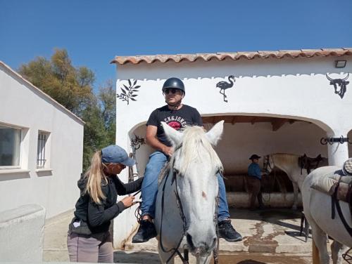une femme aide un homme sur un cheval blanc dans l'établissement Appartement, à Bollène