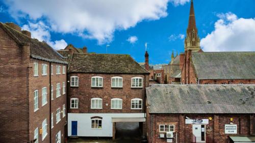 an old town with brick buildings and a church at Church Street Apartments in Kidderminster