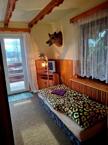 a bedroom with a bed with a cow head on the wall at Penzion Hájenka in Seč