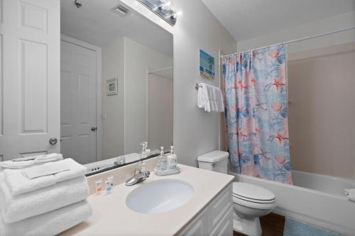 a white bathroom with a sink and a toilet at Island Royale 902 in Gulf Shores