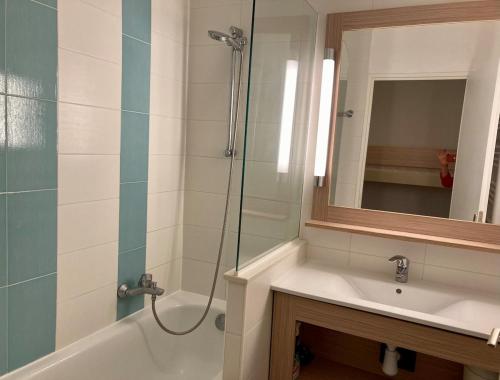 une salle de bain avec une douche, un lavabo et un miroir dans l'établissement Domaine de Valescure, à Saint-Raphaël