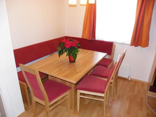 a dining room table and chairs with a vase with a plant at Ferienwohnung Ski-Hans in Planneralm