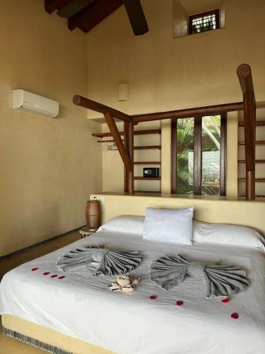 a bedroom with a white bed with towels on it at Casamar, beach front estate on Troncones Point in Troncones