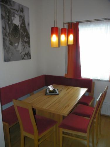 a dining room with a wooden table and chairs at Ferienwohnung Ski-Hans in Planneralm