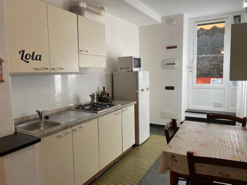 a kitchen with a sink and a refrigerator and a table at Apartment Sant'Andrea in Levanto