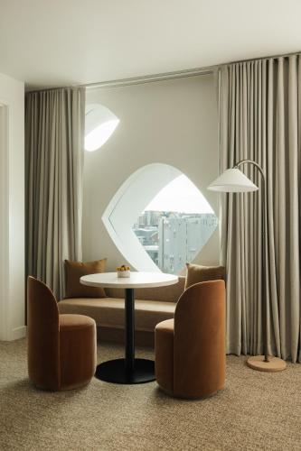 a living room with a couch and a table and chairs at Populus in Denver