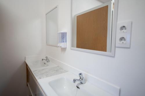 a white bathroom with a sink and a mirror at La posada in Porriño