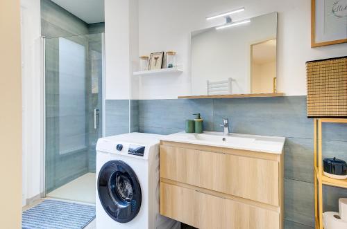 a bathroom with a washing machine and a sink at Le code de Vinci in Amboise