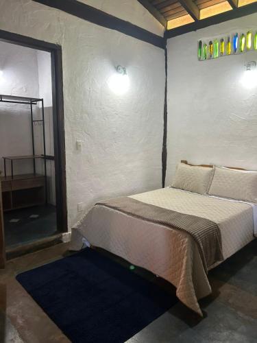 a bedroom with a bed in a room with a mirror at Pousada Mãe Terra in Torrinha
