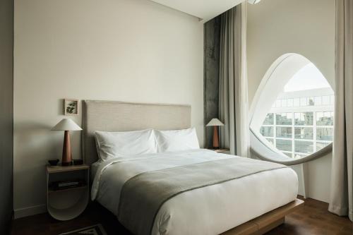 a bedroom with a large bed and a round window at Populus in Denver