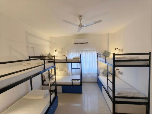 a room with four bunk beds and a ceiling at HOSHTEL99 - LUX - Stay, Cowork and Cafe - Luxurious Twin Bungalow in Pune