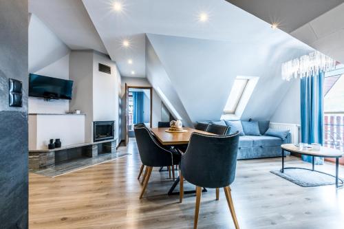Un comedor y una sala de estar con mesa y sillas. en Apartamenty Magia Tatr, en Kościelisko