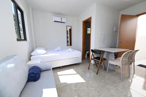 a room with a bed and a table and chairs at Studio Céu Azul, Pontal de Maracaípe PE in Porto De Galinhas