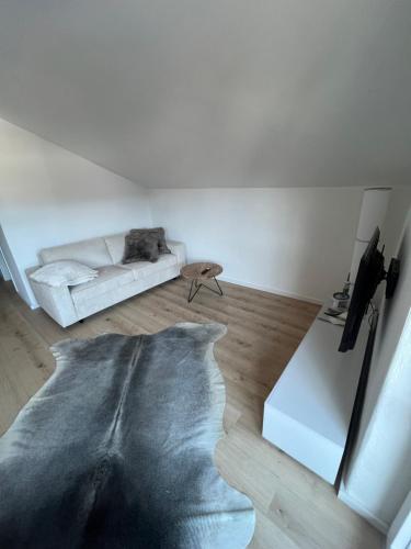 a white living room with a couch and a table at Kuschelnest im Chalet Chic, Inkl "Oberstaufen Plus Card" in Oberstaufen