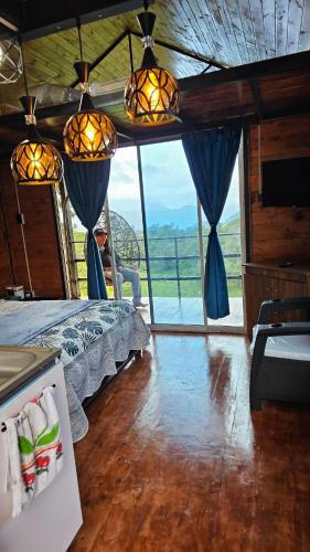 a bedroom with a bed and a large window at Hospedaje Rural Sicaru in Pacho