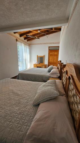 a group of three beds in a room at Los Temazcales de Xochitepec in Xochitepec