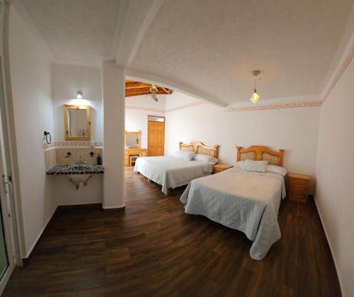 a bedroom with two beds and a sink in it at Los Temazcales de Xochitepec in Xochitepec
