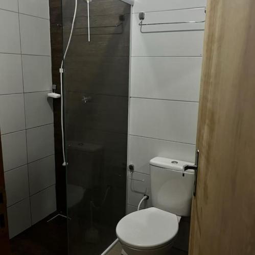 a bathroom with a toilet and a glass shower at Luciene in Xangri-lá