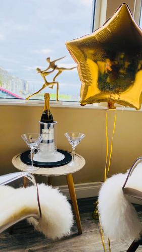 a table with two wine glasses and a window at Port Pour Deux in Portrush