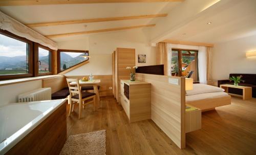 a bedroom with a bed and a desk with a table at Hotel und Residence Johanneshof in Cermes