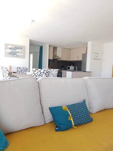 - un salon avec un canapé blanc et un oreiller bleu dans l'établissement VIlla Elise, lumineuse et proche plage, à LʼÉpine