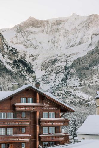 a building in front of a snow covered mountain at Hotel Fiescherblick in Grindelwald