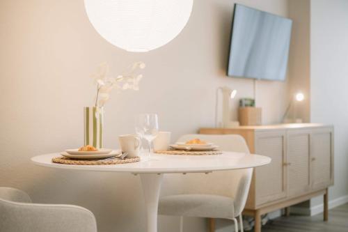 a white table with two plates of food on it at 5 Min Central 1-Room Apartment - free parking 600 mbit Wifi in Bayreuth