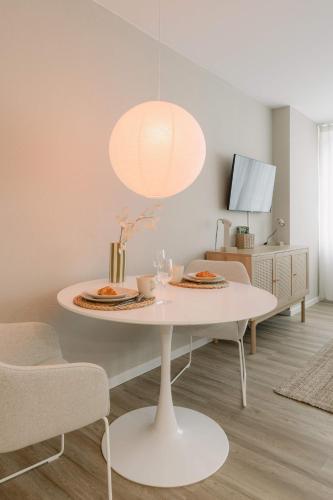 a dining room with a white table and a lamp at 5 Min Central 1-Room Apartment - free parking 600 mbit Wifi in Bayreuth
