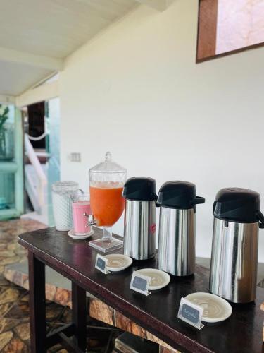 a table with two coffee makers and a drink at Pousada Bella vista in Búzios