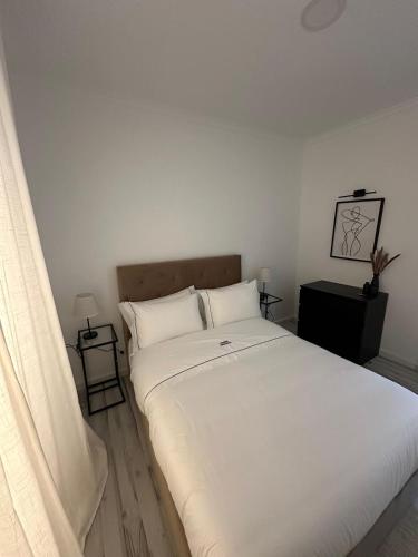 a bedroom with a large white bed with two pillows at Amadora Flat 3 in Amadora