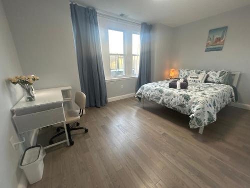 una camera da letto con un letto, una scrivania e una finestra di Cozy 2-3 Bedroom Apartment in Center City! a Philadelphia