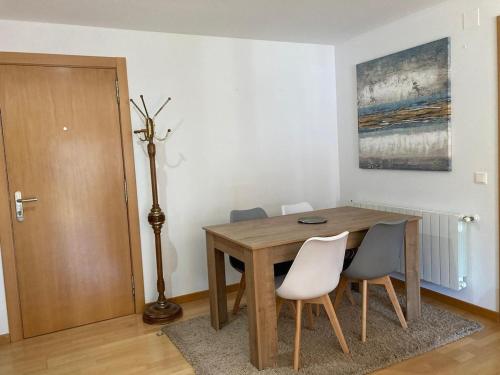 a dining room with a wooden table and chairs at Apartamento completo y equipado a 3 minutos de la playa in Bueu