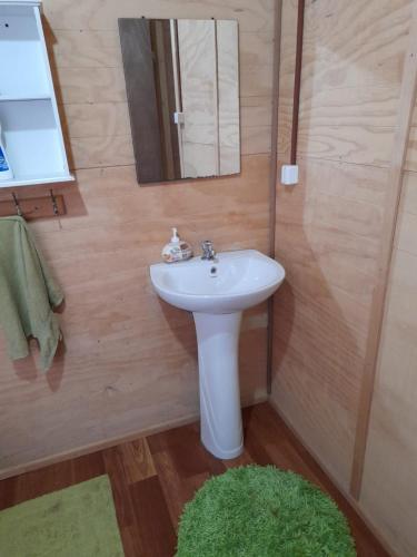 une salle de bain avec un lavabo blanc et un miroir dans l'établissement Type A cabana located in llifen, à llifen