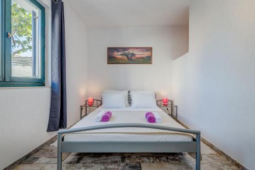a bedroom with a bed with purple pillows and a window at Apartments Deepwater in Slatine